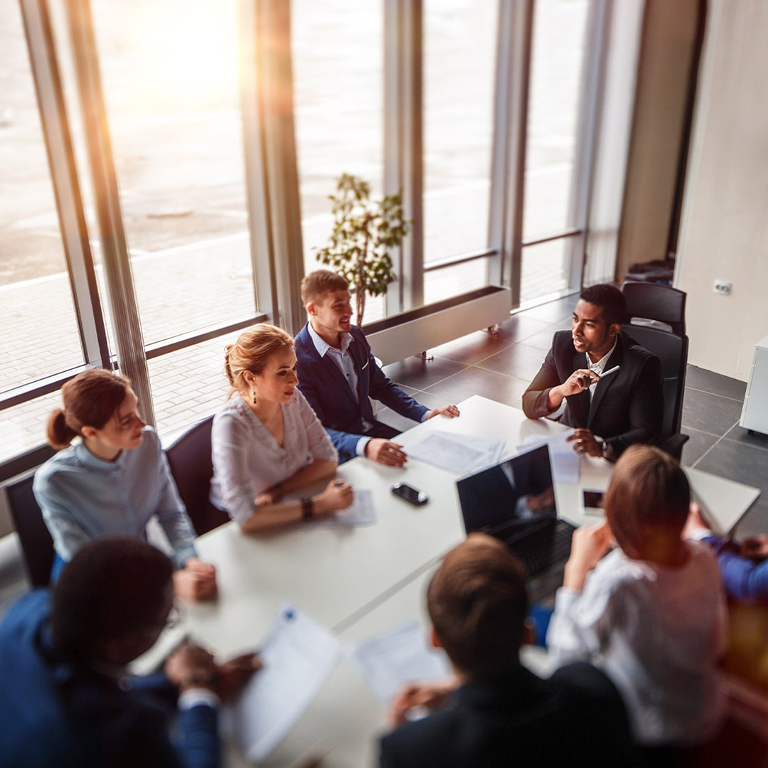 Photo of professional colleagues meeting at conference table.