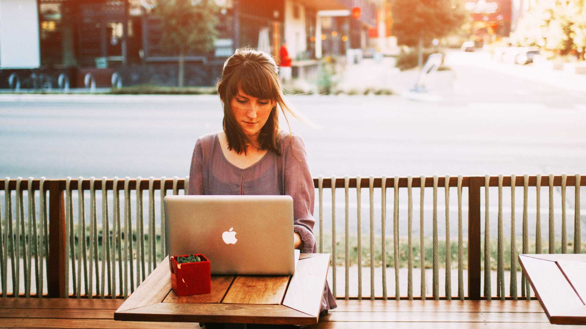 Photo of person working outside on laptop.